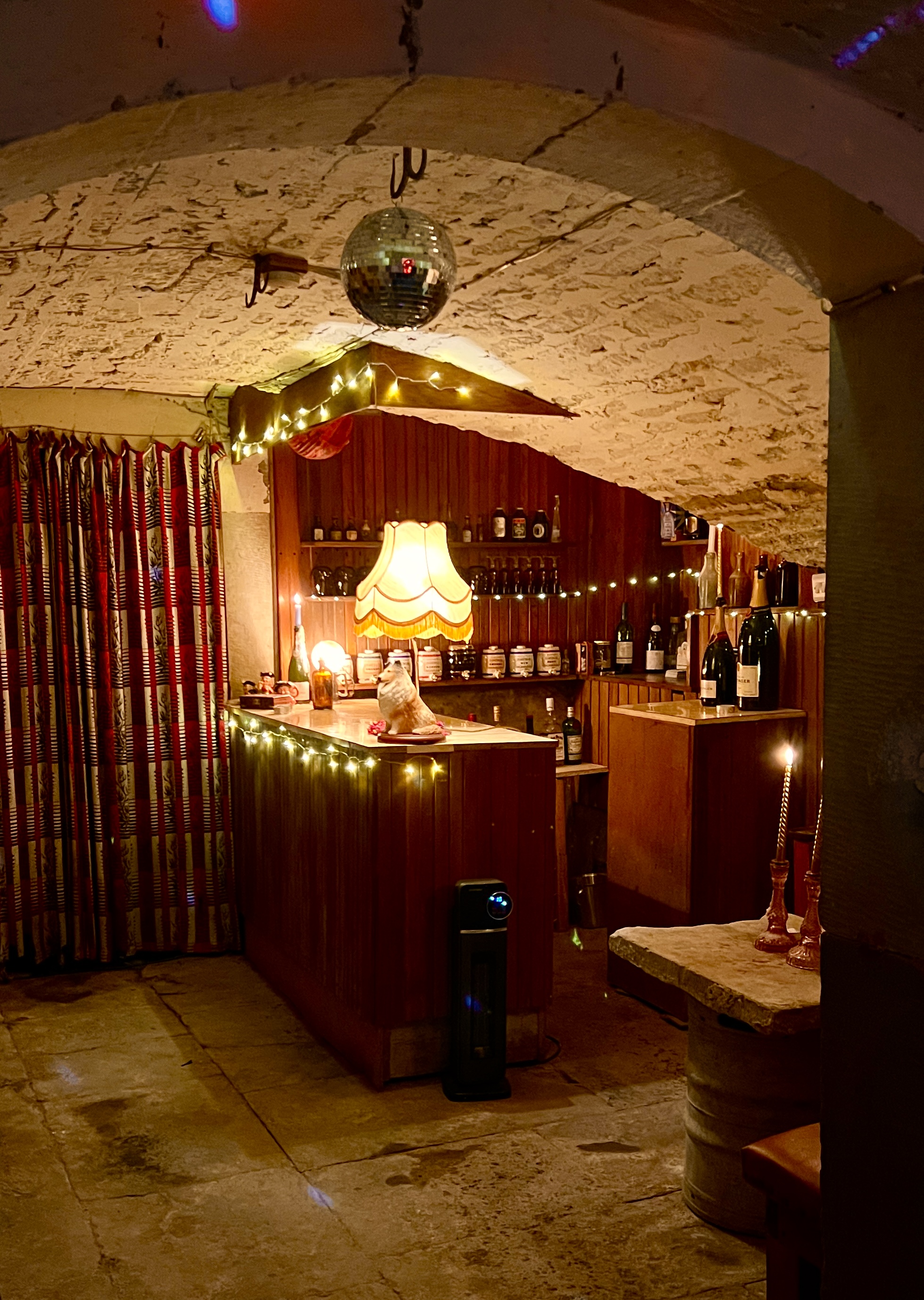Full view of cellar bar with vaulted stone ceiling and disco ball