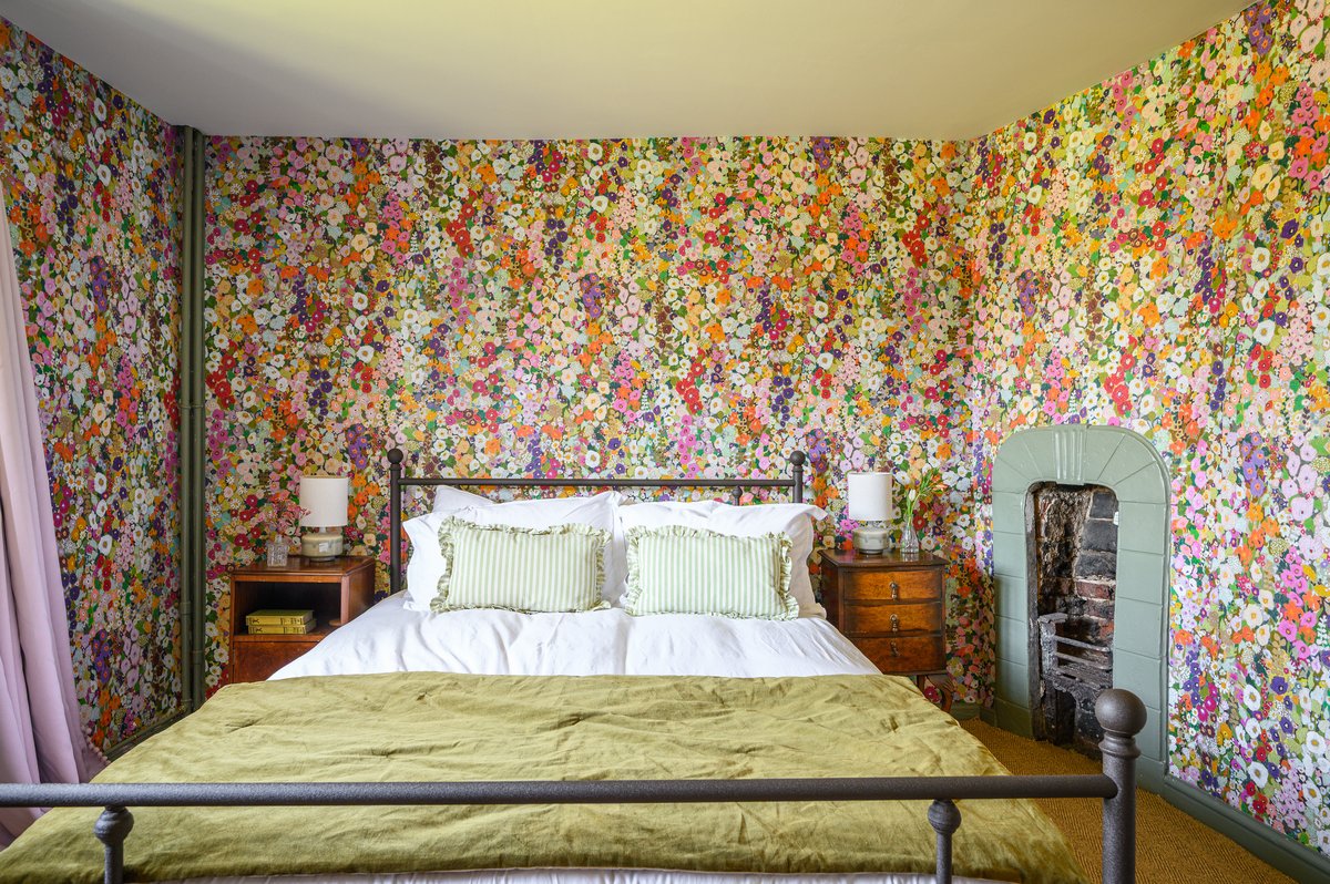 Stylish bedroom in boutique country house with floral wallpaper
