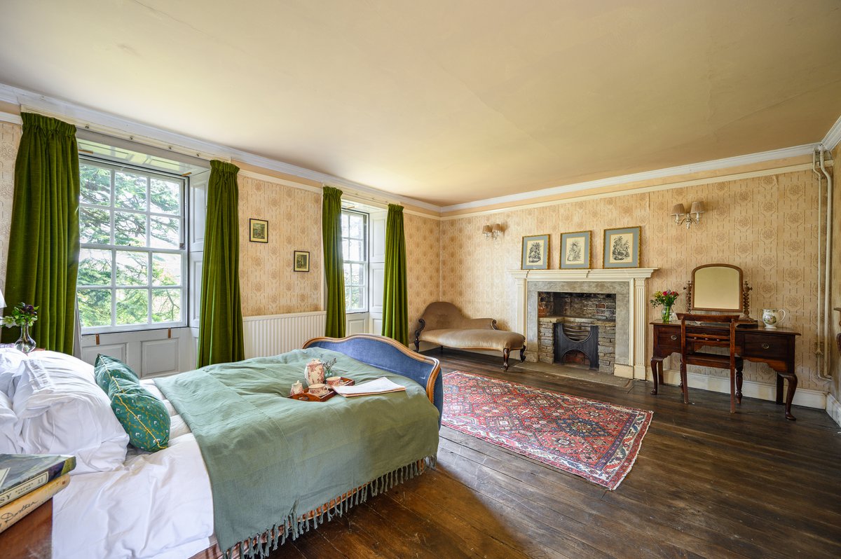 Master bedroom in luxury holiday house with fireplace and period features